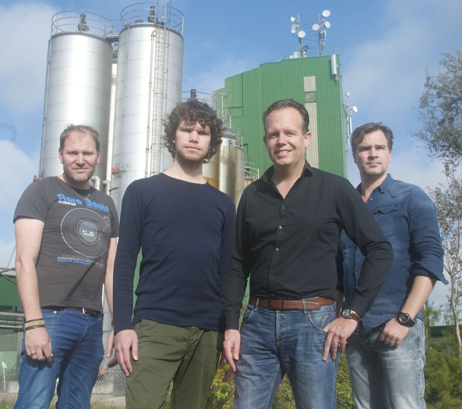 De vier bandleden van ’t Schilders Collectief voor een paar silo’s